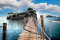 The wooden bridge overlooking the sea leads to an island with palm trees. It's a rope bridge. It is located in Zakynthos Royalty Free Stock Photo