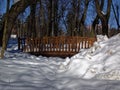 Wooden bridge in the Park across the stream in the snow