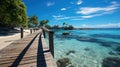 Wooden bridge or pier on tropical white sand beach with clear blue sea and sky on sunny day. Boardwalk into the ocean Royalty Free Stock Photo