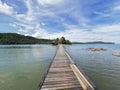 Wooden bridge to home stay near small rock island with clear crystal water.