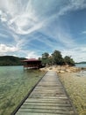 Wooden bridge to home stay near small rock island with clear crystal water.