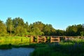 A wooden bridge of tree logs lies across a small river inside a wooded area among green nature Royalty Free Stock Photo