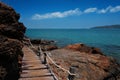 Wooden bridge walkway along the rocks coast and sea with blue sky summer time Royalty Free Stock Photo