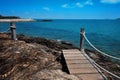 Wooden bridge walkway along the rocks coast and sea with blue sky summer time Royalty Free Stock Photo