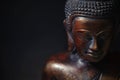 Wooden bronze buddha on black background close up