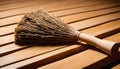 A wooden broom rests on a wooden floor