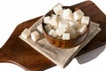 In a wooden brown bowl, white lumpy beet sugar in the form of a cube on a linen napkin. Royalty Free Stock Photo