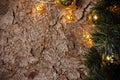 A wooden brown Christmas background with a spruce branch, garland, yellow and gold balls. Empty space for text. Happy New Year. Royalty Free Stock Photo