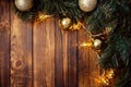 A wooden brown Christmas background with a spruce branch, a New Year`s garland, yellow and gold balls. Empty space. happy new yea Royalty Free Stock Photo