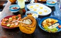 Wooden brown cracked table set with Breakfast of natural healthy food, scrambled eggs, oatmeal, omelette with vegetables, fruit, Royalty Free Stock Photo