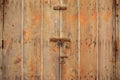 Wooden brown door background locked with rusty padlock. Weathered closed doorway, close up view with details. Royalty Free Stock Photo