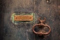 Wooden brown door background with rusty letterbox and rusty handle. Aged closed gate, close up view with details.