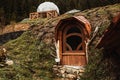 Wooden brown door to a small house on a hill on a mountain in the woods like a hobbit