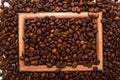 Wooden brown frame on coffee beans background. Concept of coffee drink time. Royalty Free Stock Photo