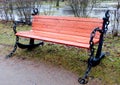 Wooden brown bench with iron anchors on the sides in the Park