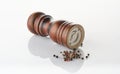 Wooden brown pepper mill with black peppercorns on white background Royalty Free Stock Photo