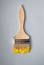 Wooden brush on a blue background. Yellow paint.