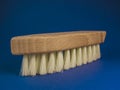 Wooden brush for cleaning shoes on a blue background Royalty Free Stock Photo