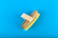 Wooden brush massager. massage wooden soft body brush with natural pile, worn on the hand, on a blue background, used in the