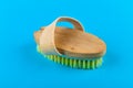 Wooden brush massager. massage wooden soft body brush with natural pile, worn on the hand, on a blue background, used in the