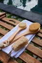 Natural bristle brushes and a loofah scrubber lie against the backdrop of the pool. Zero waste concept Royalty Free Stock Photo