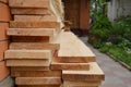 Wooden building materials: A stack of wood boards, planks and sawn timber stored near the house during house renovation. Timber Royalty Free Stock Photo