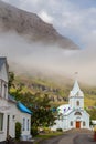 Wooden buildings and church in the port city of Seydisfjordur located by the fjord, Iceland