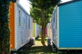 Wooden bungalows inside a summer campsite with brightly painted boards