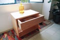 wooden bureau on top of a rug, side table, night table