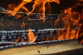 Wooden burning hot charred planks of wood logs in a fire with tongues of fire and smoke. Texture, background Royalty Free Stock Photo