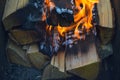 Wooden burning hot charred planks of wood logs in a fire with tongues of fire and smoke. Texture, background Royalty Free Stock Photo