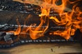 Wooden burning hot charred planks of wood logs in a fire with tongues of fire and smoke. Texture, background Royalty Free Stock Photo