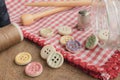 Wooden buttons with colored stripes of colors on a red and white checkered tablecloth Royalty Free Stock Photo