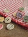 Wooden buttons with colored stripes of colors on a red and white checkered tablecloth Royalty Free Stock Photo