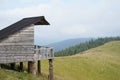 A wooden cabin with a panoramic view of the mountains and the forest. A place for tourists to rest, the home of a forester or Royalty Free Stock Photo