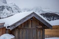 Wooden cabin with the roof covered in snow near mountains in the winter Royalty Free Stock Photo