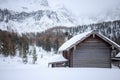 Wooden cabin with the roof covered in snow near mountains in the winter Royalty Free Stock Photo
