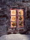 Wooden cabin window with illuminated christmas tree Royalty Free Stock Photo