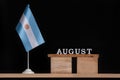 Wooden calendar of August with Argentine flag on black background. Dates of Argentina in August Royalty Free Stock Photo