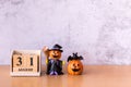 Wooden calendar block disrupted show date 31 october halloween day and toy pumpkin on wooden background. Halloween concept