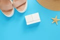 Wooden calendar on a blue background with summer accessories. Empty white cubes