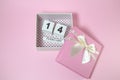 Wooden calendar in the pink gift box on the pink background. Royalty Free Stock Photo