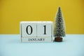 Wooden calendar 1st January with chirtsmas tree on yellow and blue background Royalty Free Stock Photo