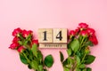 Wooden calendar 14th February and roses on pink background