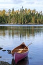 Wooden canoe near shore of Boundary Waters lake in Minnesota on an autumn morning