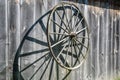 Wooden cartwheel shading on the plank wall of a barn