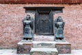 Wooden carved entrance door with carved statues on sides at Durbar Square, Bhaktapur, Kathmandu Valley, Nepal