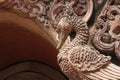 Wooden carved peacock above an archway in temple grounds Northern Thailand, Chiang Mai