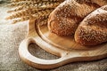 Wooden carving board bread wheat ears on sacking background Royalty Free Stock Photo