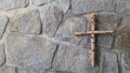 Wooden Catholic cross formed from birch tree on a stone wall Royalty Free Stock Photo